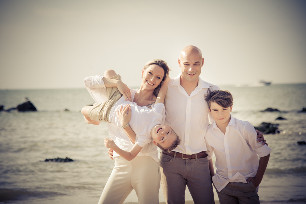 gezinsfoto met zee op de achtergrond